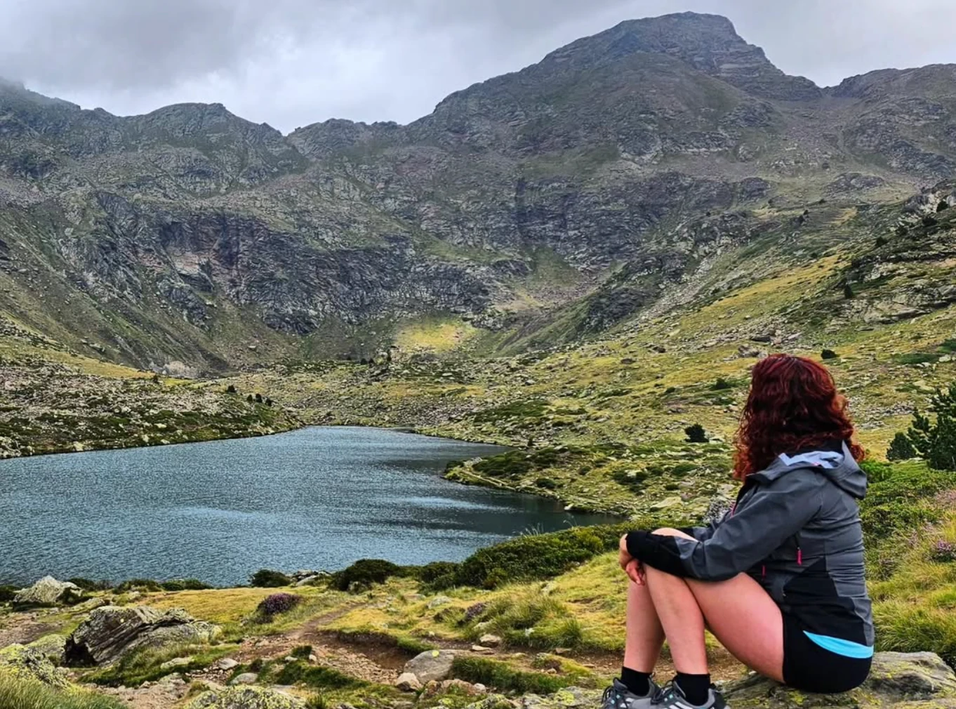 Yasmin sentada junto al lago de Tristaina, contemplando las montañas
